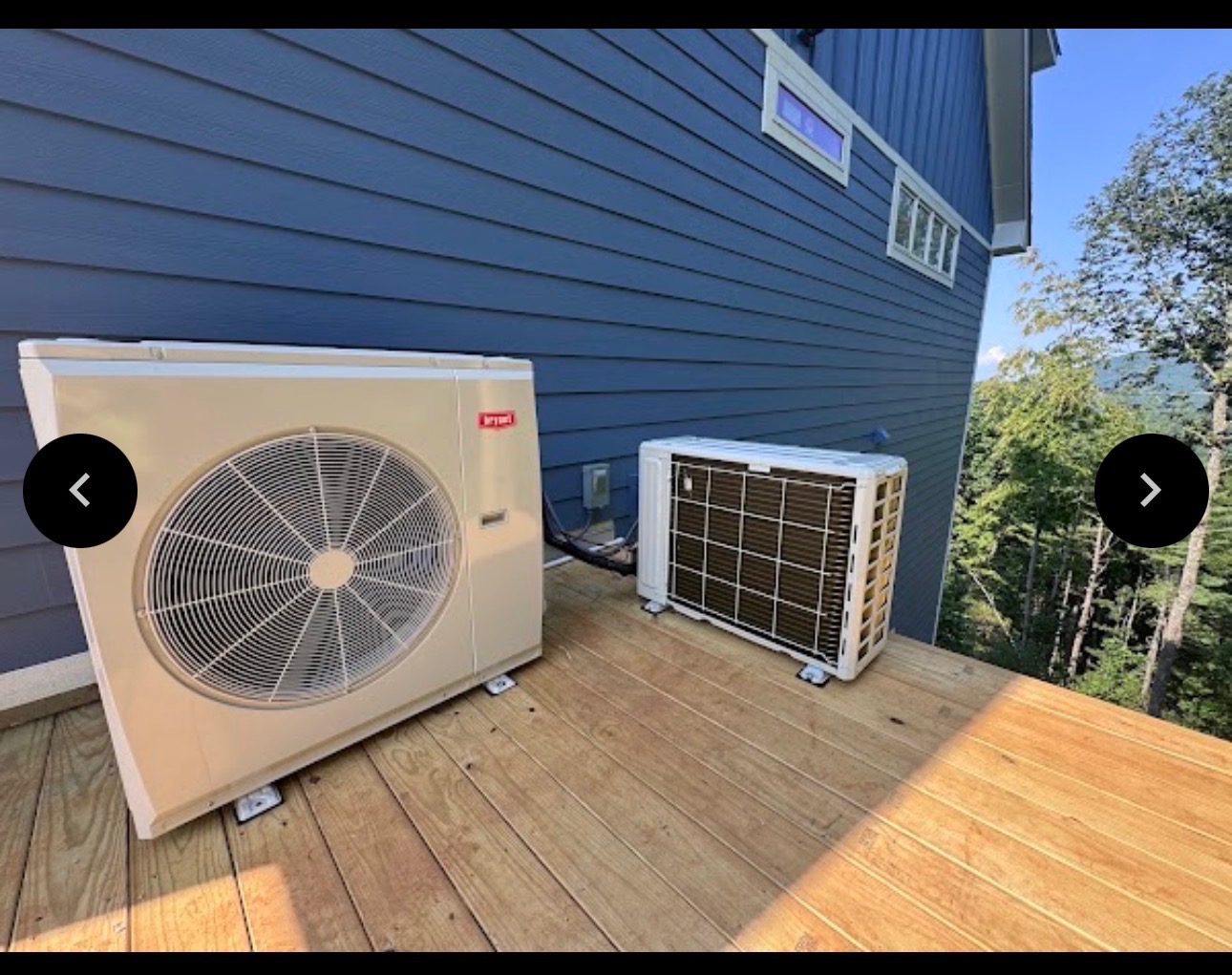 Bryant HVAC unit and companion unit on a wooden deck next to a blue house