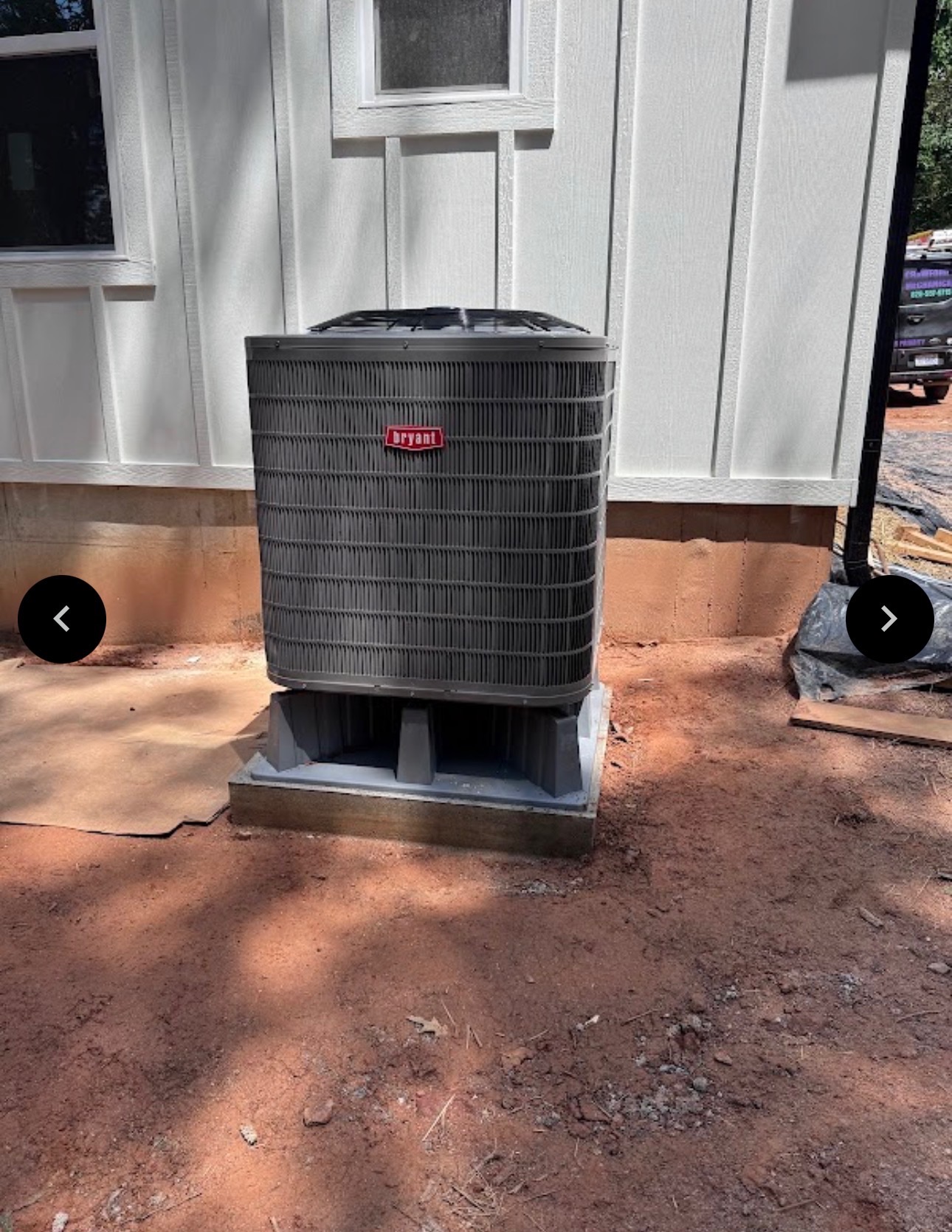 Vertical Bryant HVAC unit on a concrete pad in a dirt yard