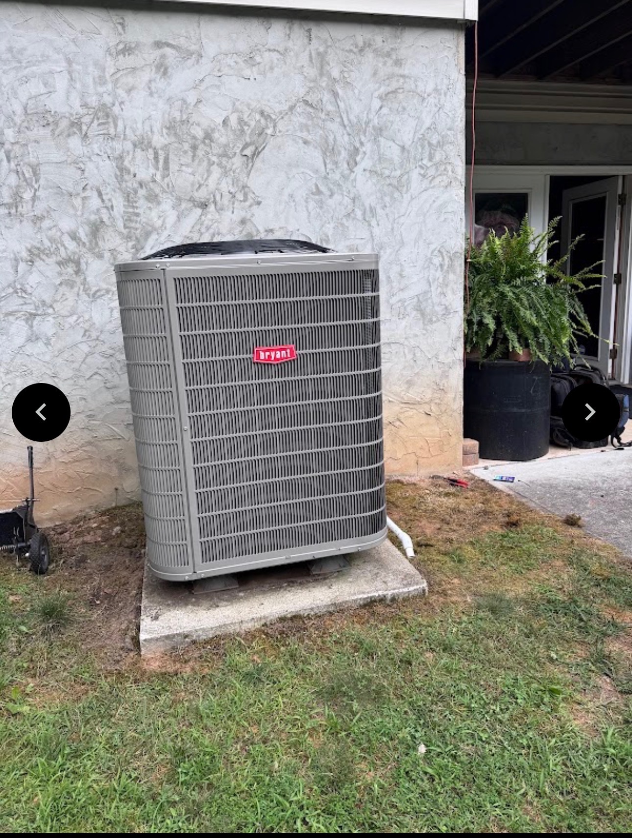 Bryant HVAC unit on a concrete pad against a stucco wall
