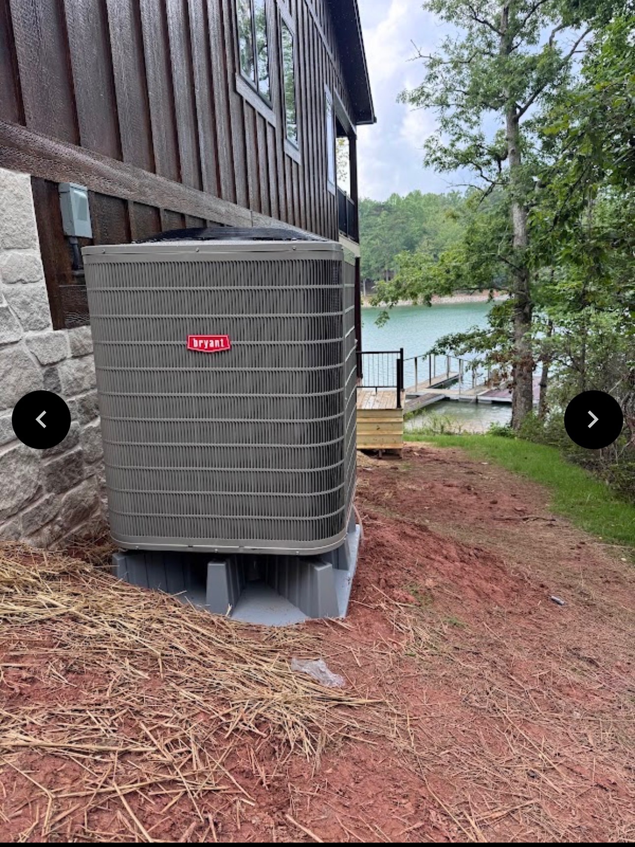 Bryant HVAC unit near a lake house with a dock in the background